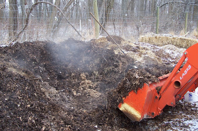 A backhoe scooping up a large pile of dirt.