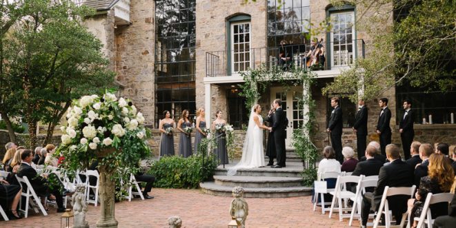 Bride and groom at the altar, holding hands, with guests seated in their chairs.