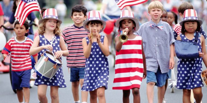 A line of young children dressed in patriotic red, white, and blue clothing and accessories.