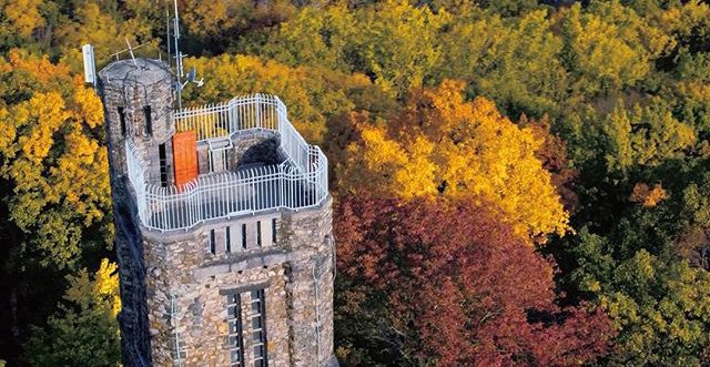 Aerial view of Bowman's Hill Tower surrounded by autumn-colored trees.