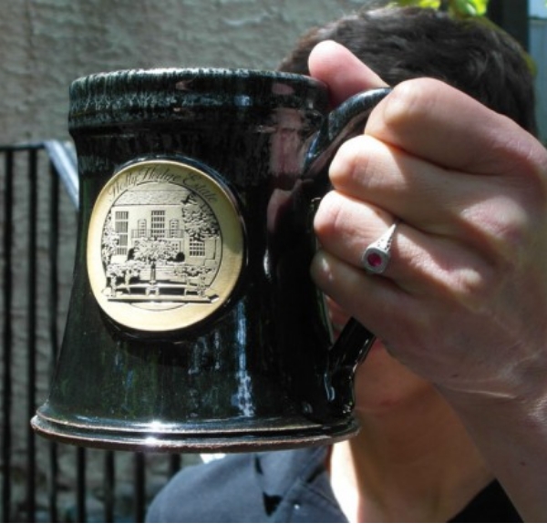 Headshot of Michele Stulpin holding a "HollyHedge Estate" mug