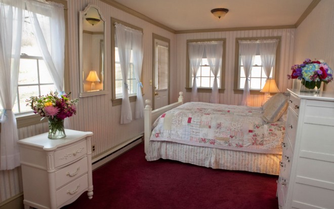 Photo of Room 3: A standard room with many windows and white wood bed, dresser, and nightstand